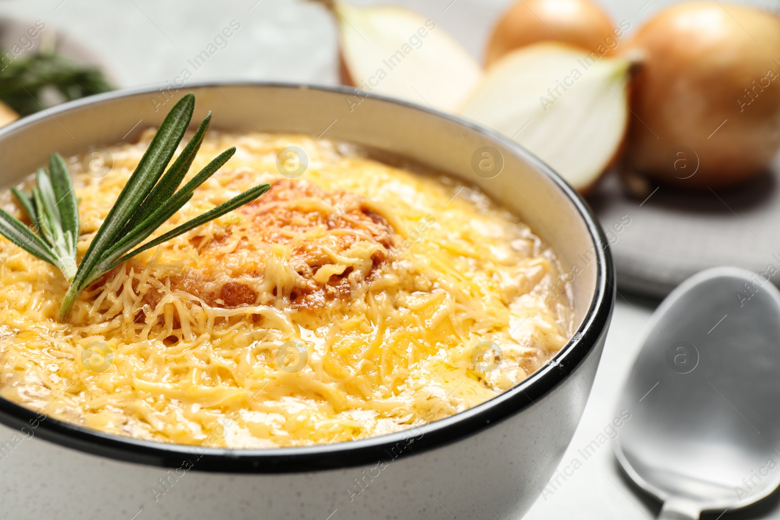 Photo of Tasty homemade french onion soup served in ceramic bowl, closeup