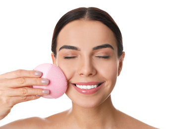 Photo of Young woman using facial cleansing brush on white background. Washing accessory