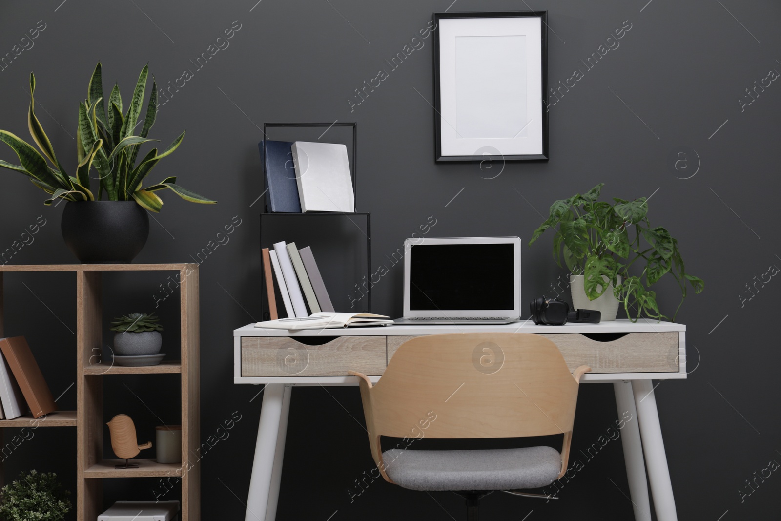 Photo of Workplace with laptop, stationery on desk and chair in home office