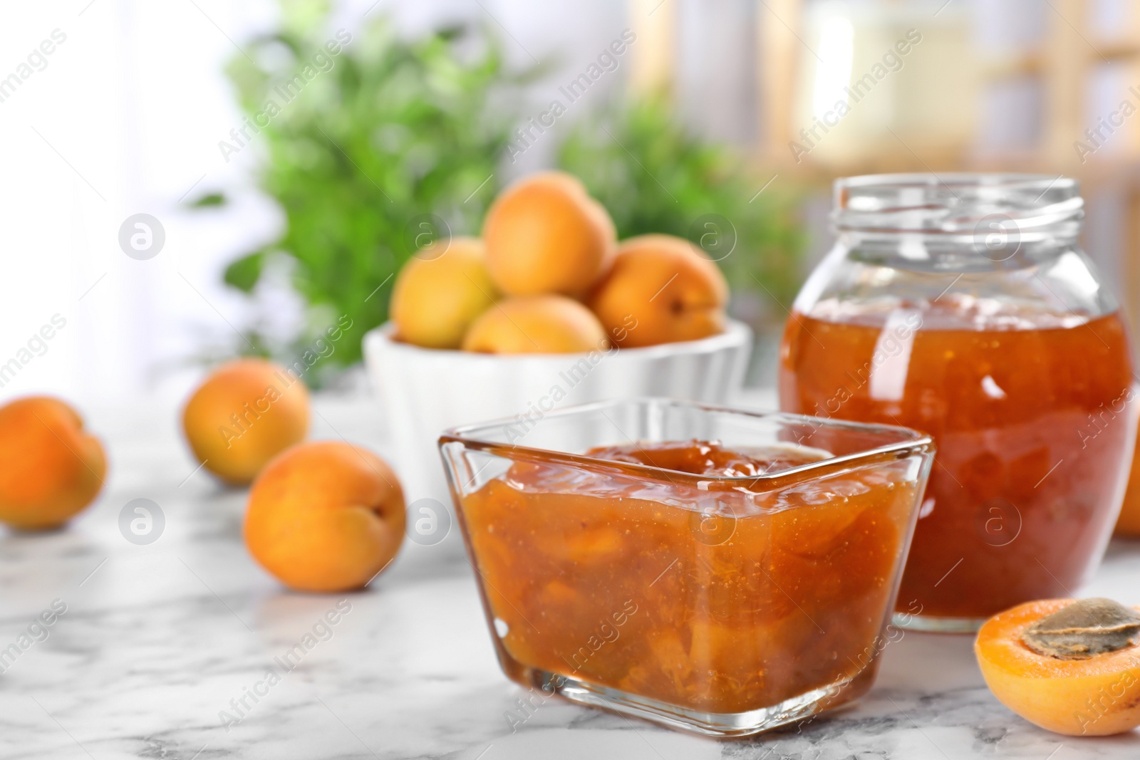 Photo of Bowl with tasty apricot jam on table