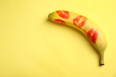 Photo of Fresh banana with red lipstick marks on yellow background, space for text. Oral sex concept