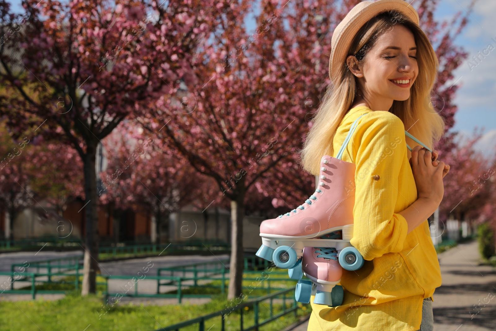 Photo of Young woman with roller skates in spring park