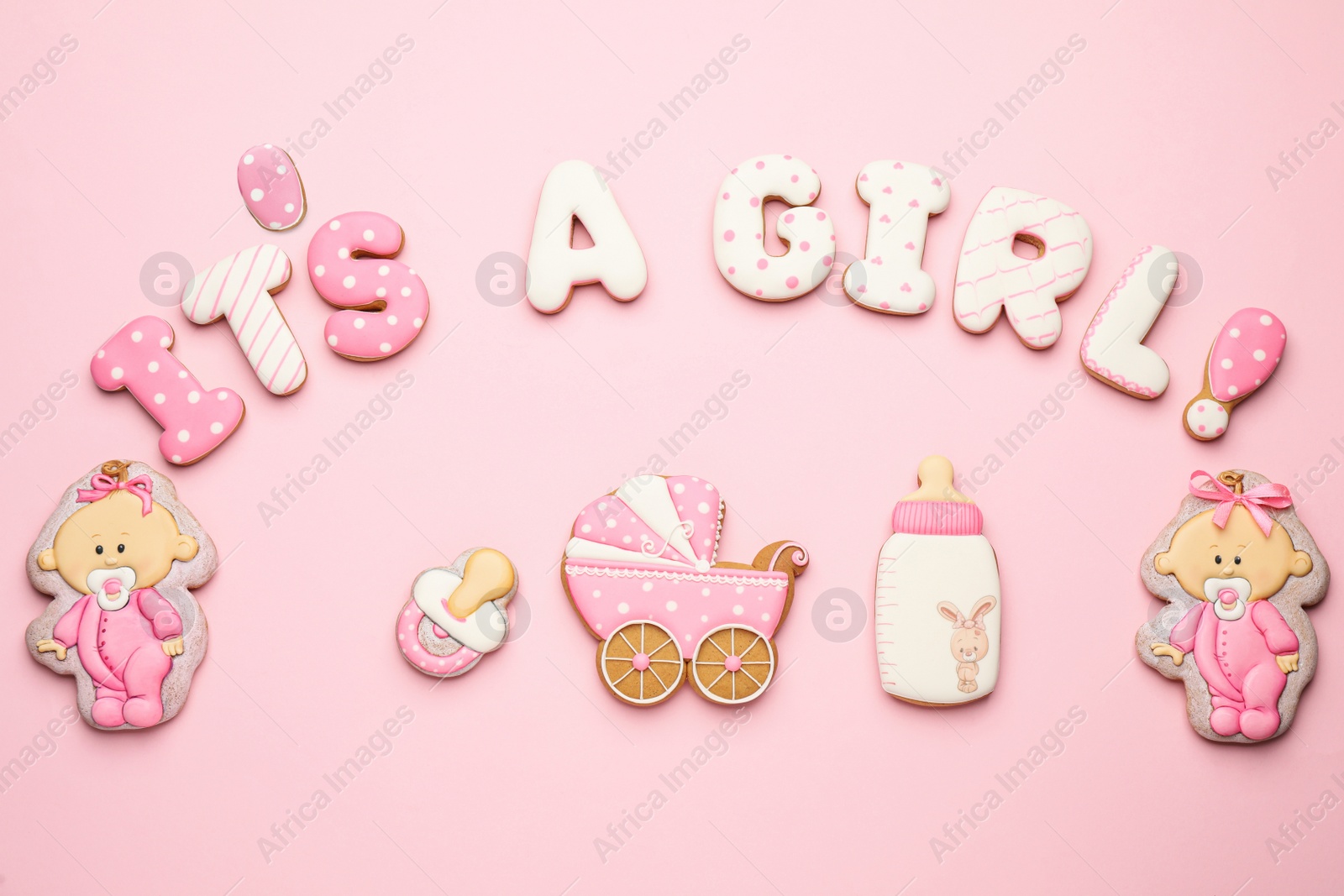 Photo of Phrase IT IS A GIRL and tasty cookies on pink background, flat lay. Baby shower party