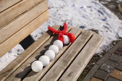 Photo of Snowballs and plastic tool on bench outdoors