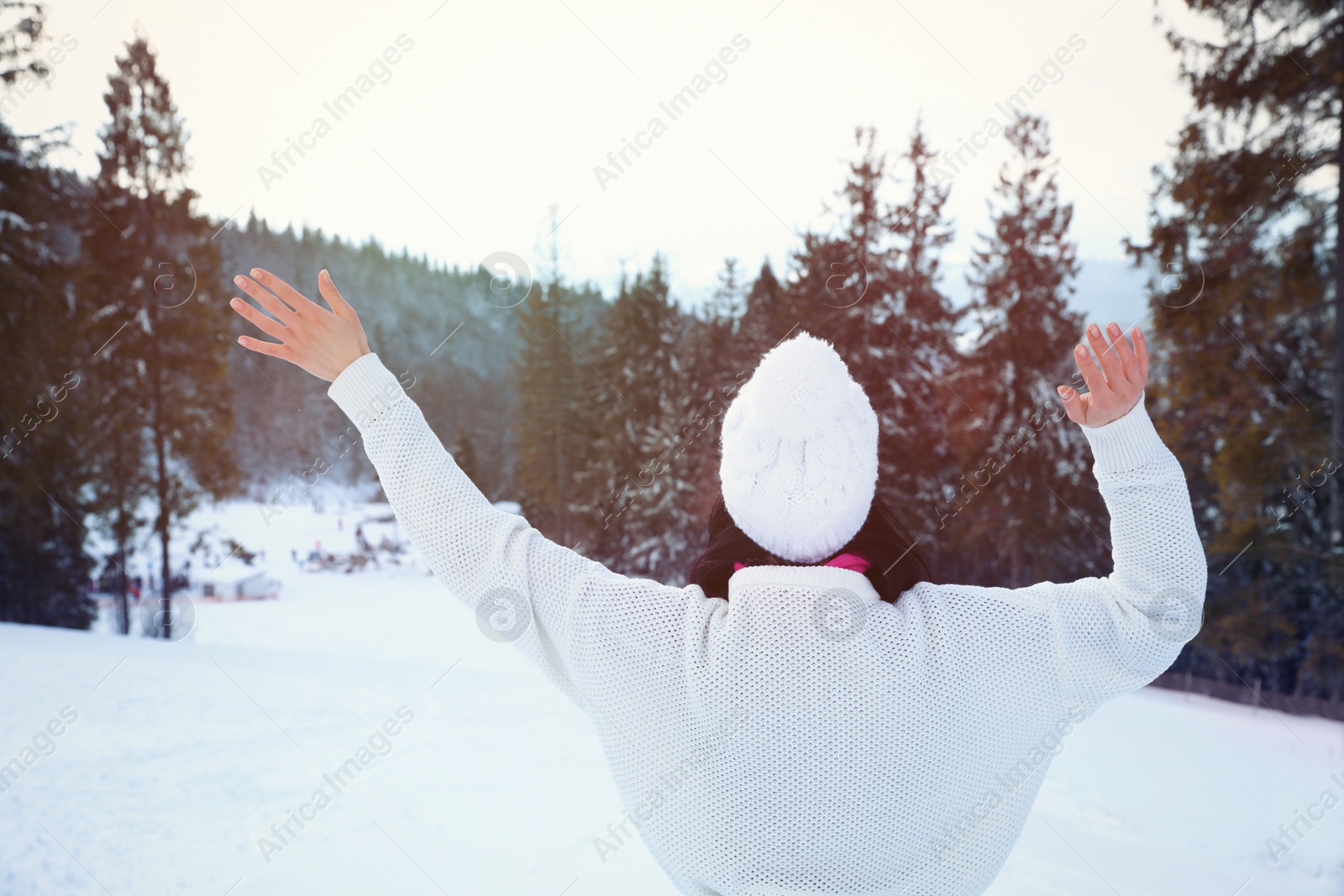 Photo of Young woman at mountain resort, back view. Winter vacation