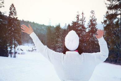 Young woman at mountain resort, back view. Winter vacation