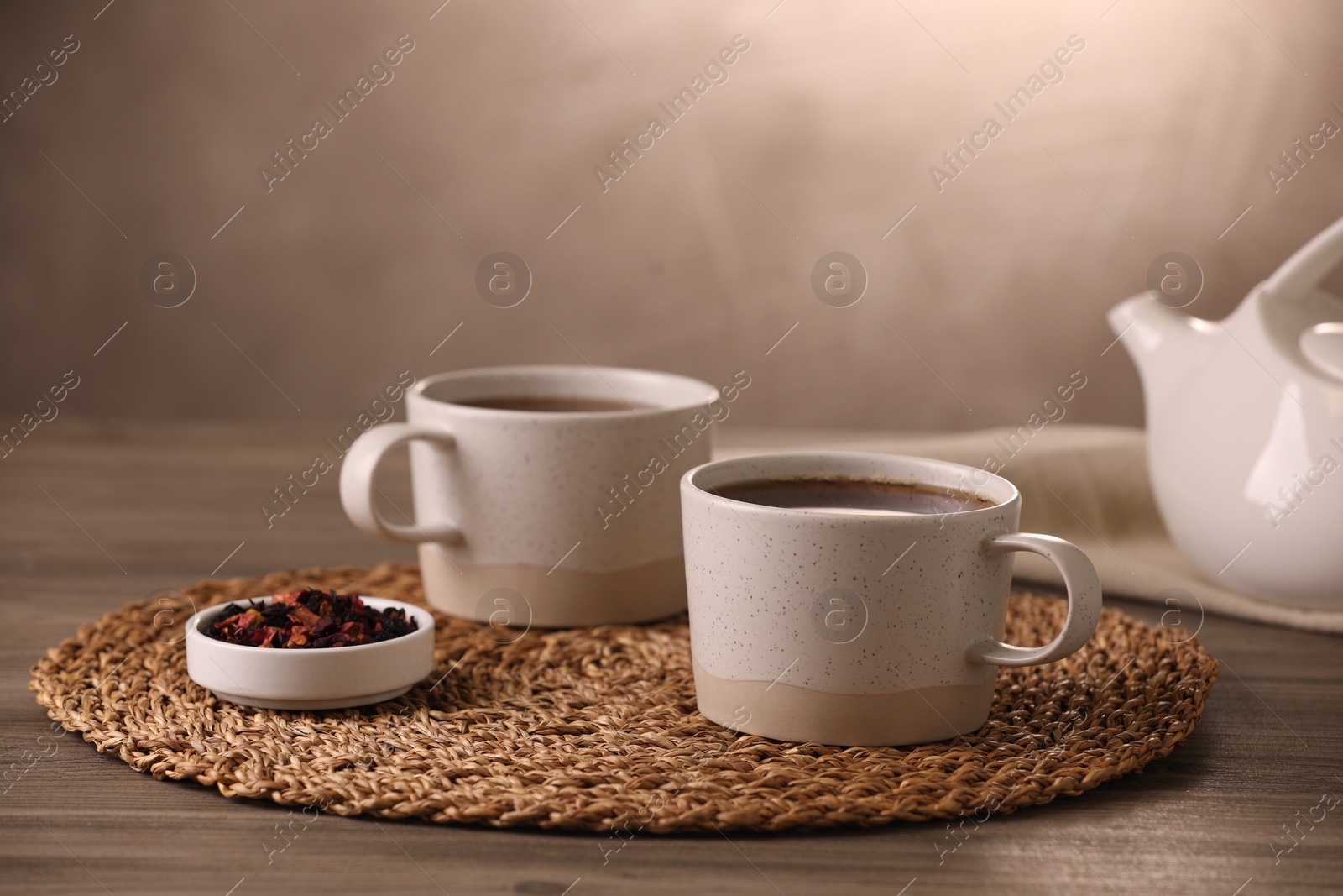 Photo of Aromatic tea and dry flower petals on wooden table