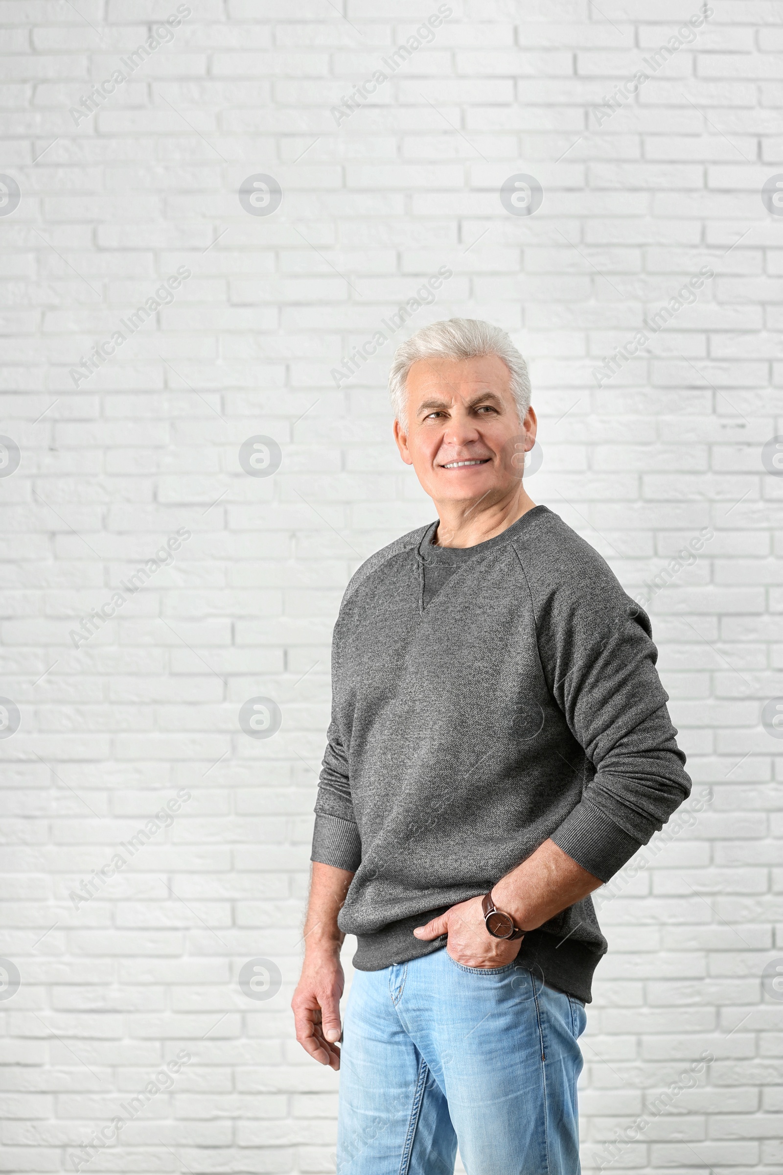 Photo of Portrait of handsome mature man near brick wall