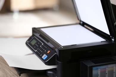 Photo of New modern multifunction printer on table indoors, closeup