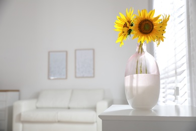 Beautiful bouquet of sunflowers in vase on table indoors. Space for text