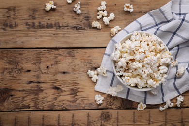 Photo of Bowl of tasty popcorn on wooden table, flat lay. Space for text