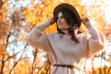 Beautiful young woman wearing stylish sweater in autumn park