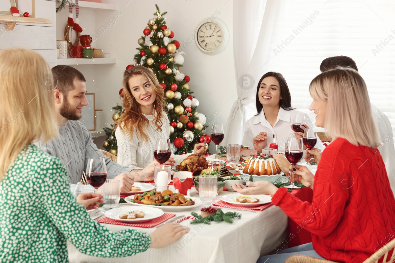 Photo of Happy family with their friends enjoying festive dinner at home. Christmas Eve celebration