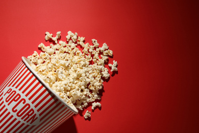 Photo of Delicious popcorn on red background, top view. Space for text