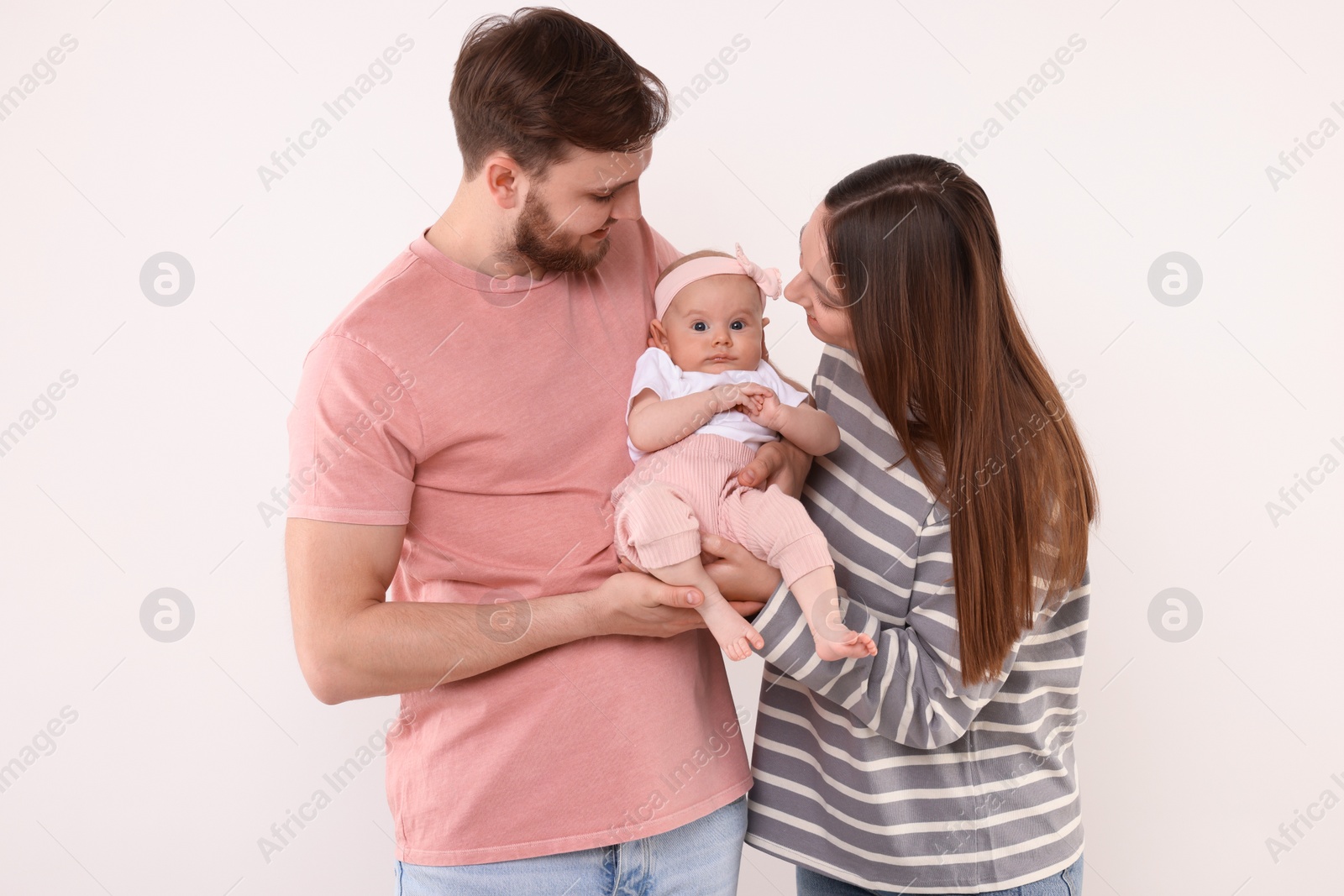 Photo of Happy family. Parents with their cute baby on light background