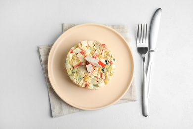 Photo of Delicious salad with fresh crab sticks on white table, flat lay