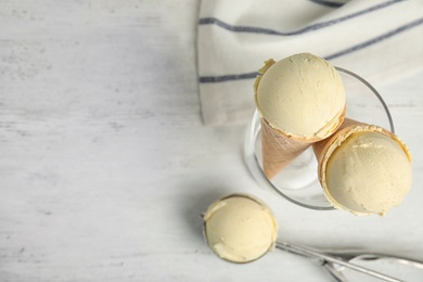 Flat lay composition with delicious vanilla ice cream on wooden table. Space for text