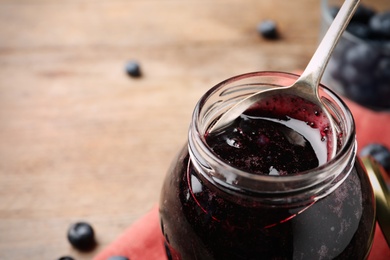 Photo of Jar of delicious blueberry jam, closeup view. Space for text