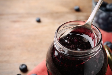 Jar of delicious blueberry jam, closeup view. Space for text