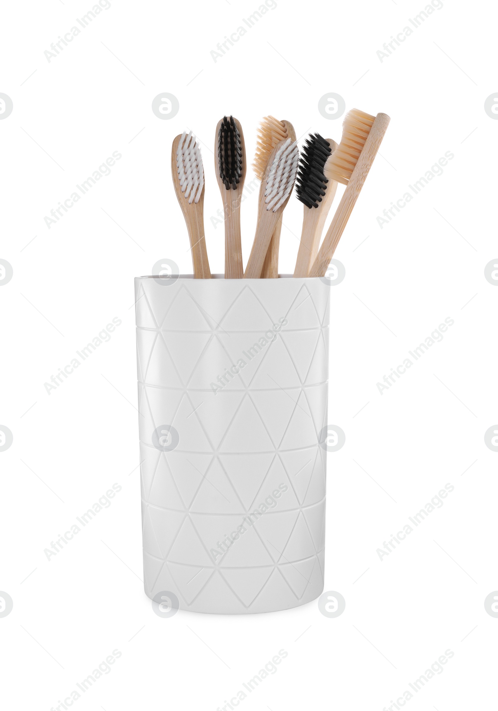 Photo of Bamboo toothbrushes in holder isolated on white