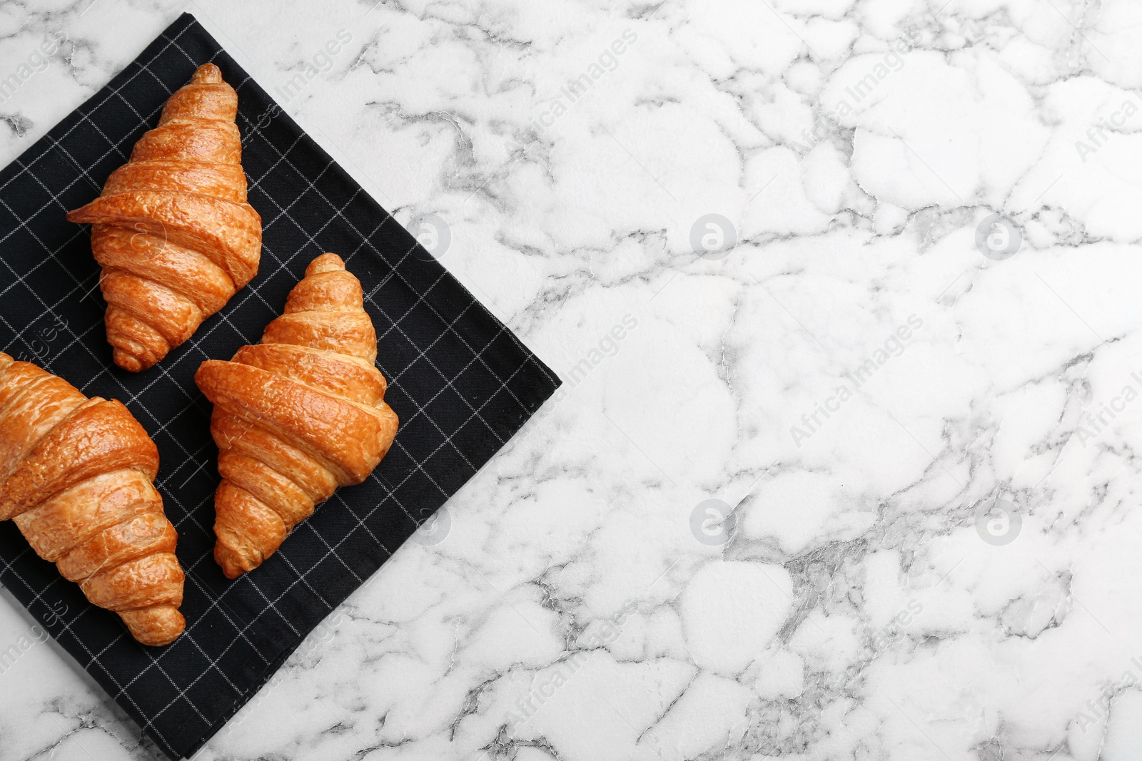 Photo of Fresh croissants on white marble table, flat lay with space for text. French pastry