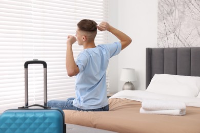 Photo of Guest stretching on bed in stylish hotel room