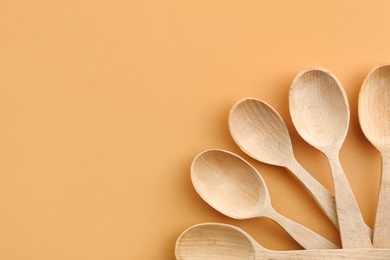 Flat lay composition with clean wooden spoons and space for text on color background