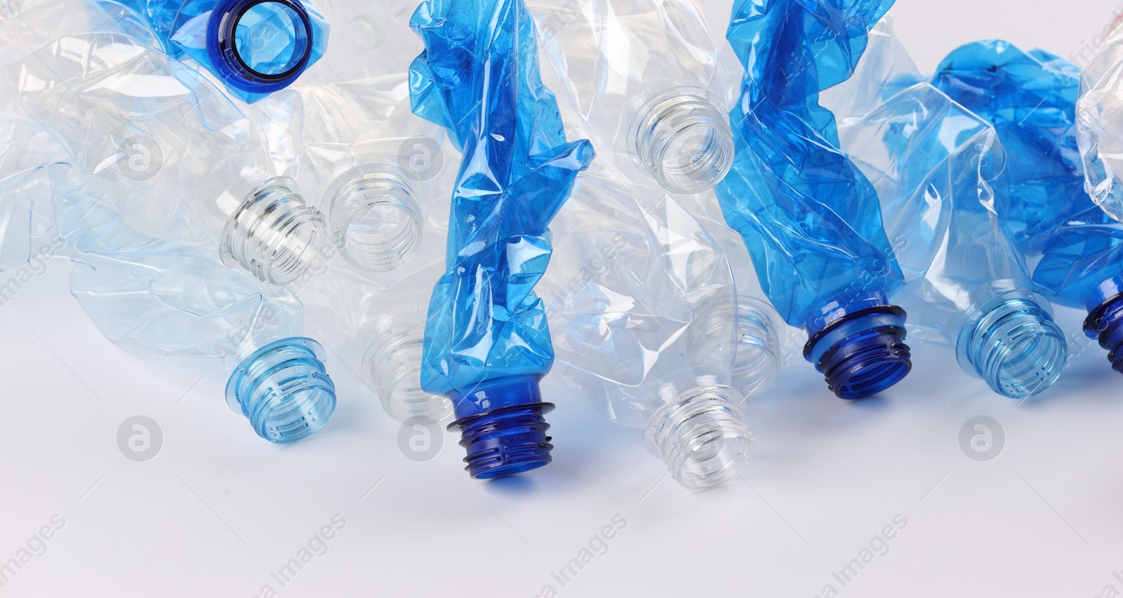 Photo of Crumpled disposable plastic bottles on white background