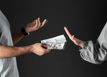 Woman refusing to take bribe on black background, closeup