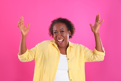 Photo of Portrait of happy African-American woman on pink background