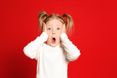 Photo of Portrait of cute little girl on red background