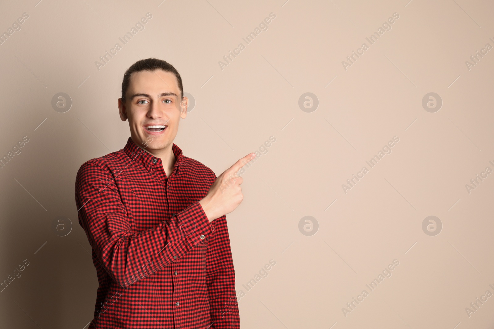 Photo of Portrait of happy young man on beige background. Space for text