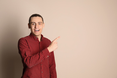 Portrait of happy young man on beige background. Space for text