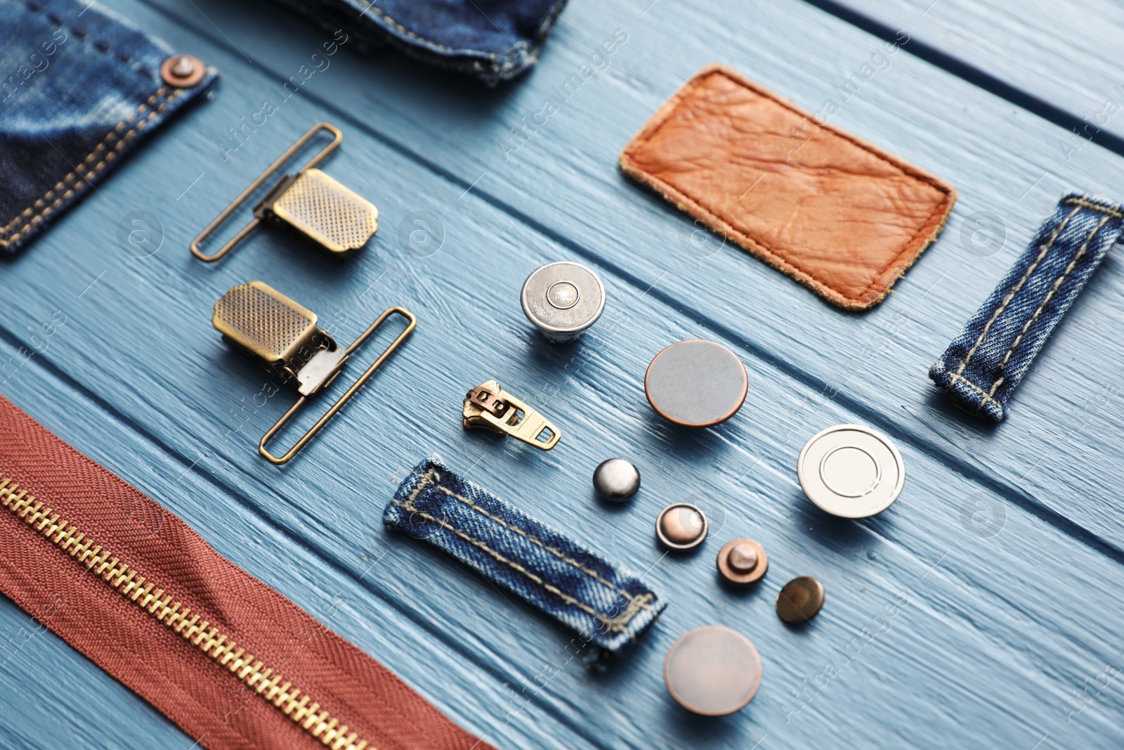 Photo of Composition with garment accessories and cutting details for jeans on light blue wooden background