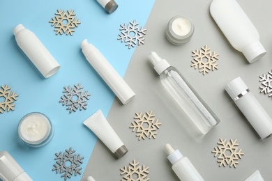 Flat lay composition with cosmetic products on light blue and grey background. Winter care
