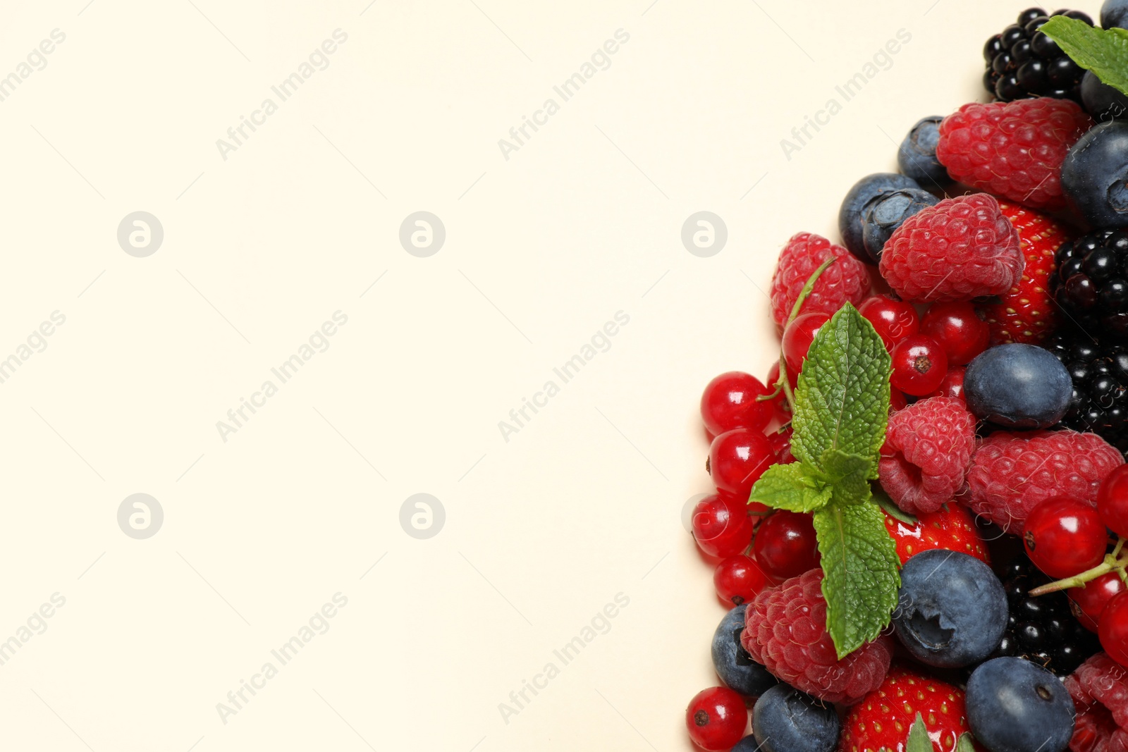 Photo of Mix of different fresh berries and mint on light background, flat lay. Space for text