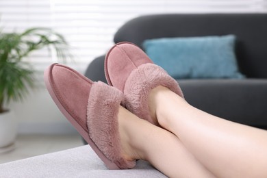 Photo of Woman in pink soft slippers resting at home, closeup