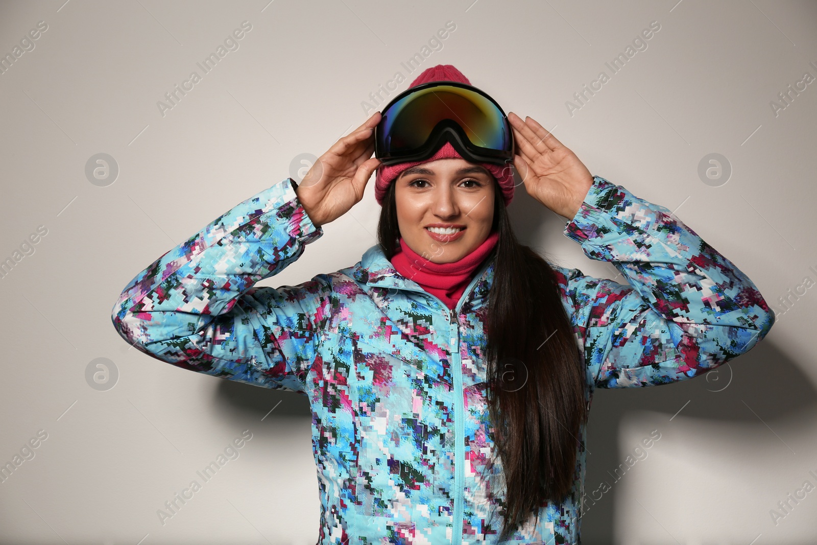 Photo of Woman wearing stylish winter sport clothes on light grey background