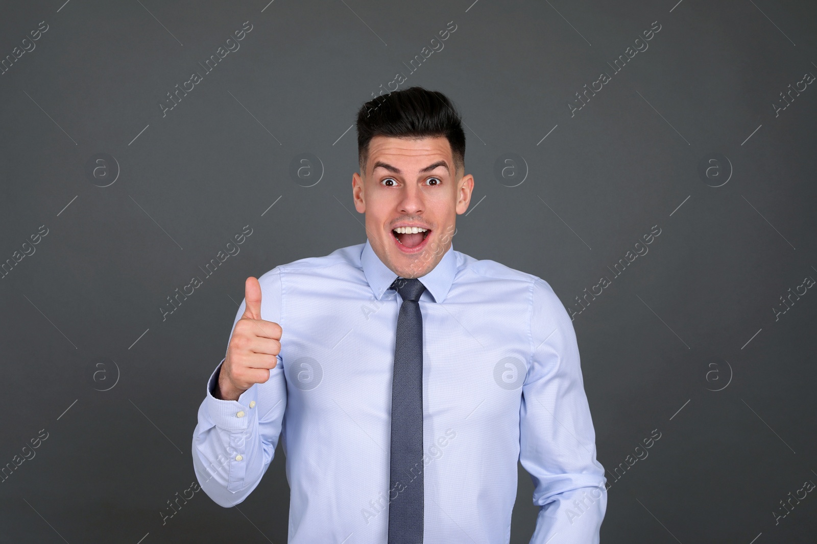 Photo of Portrait of happy businessman on dark grey background. Personality concept