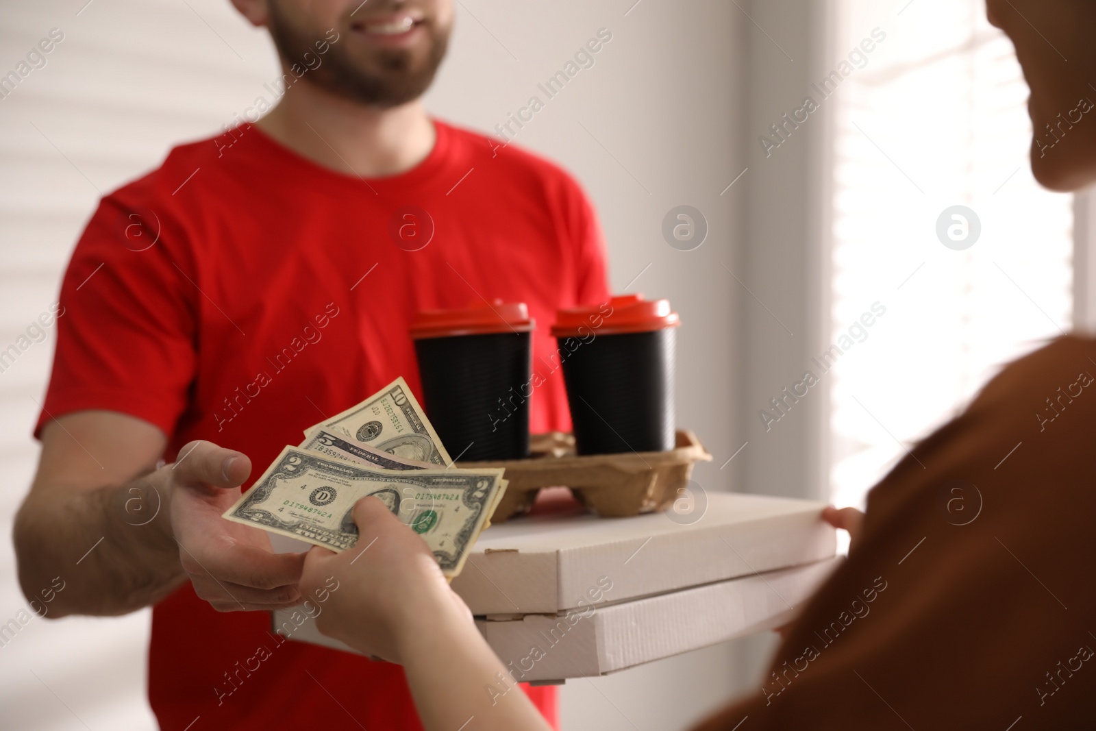 Photo of Deliveryman receiving tips from woman indoors, closeup