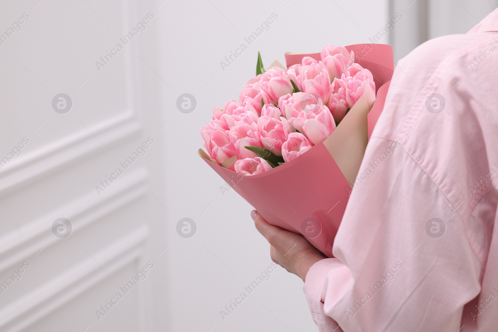 Photo of Woman with bouquet of beautiful fresh tulips on blurred background, closeup. Space for text