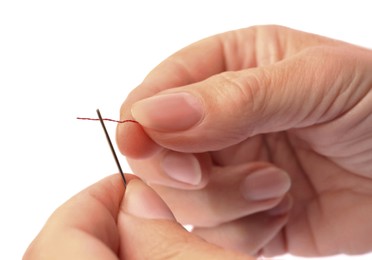 Photo of Woman threading sewing needle on white background, closeup