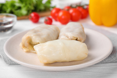 Photo of Delicious cabbage rolls on white wooden table, closeup