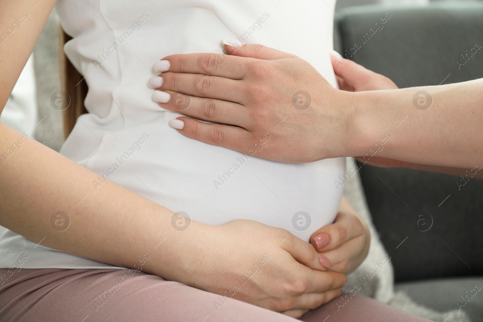 Photo of Doula taking care of pregnant woman indoors, closeup. Preparation for child birth