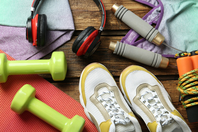 Photo of Set of fitness equipment and accessories on wooden background, flat lay