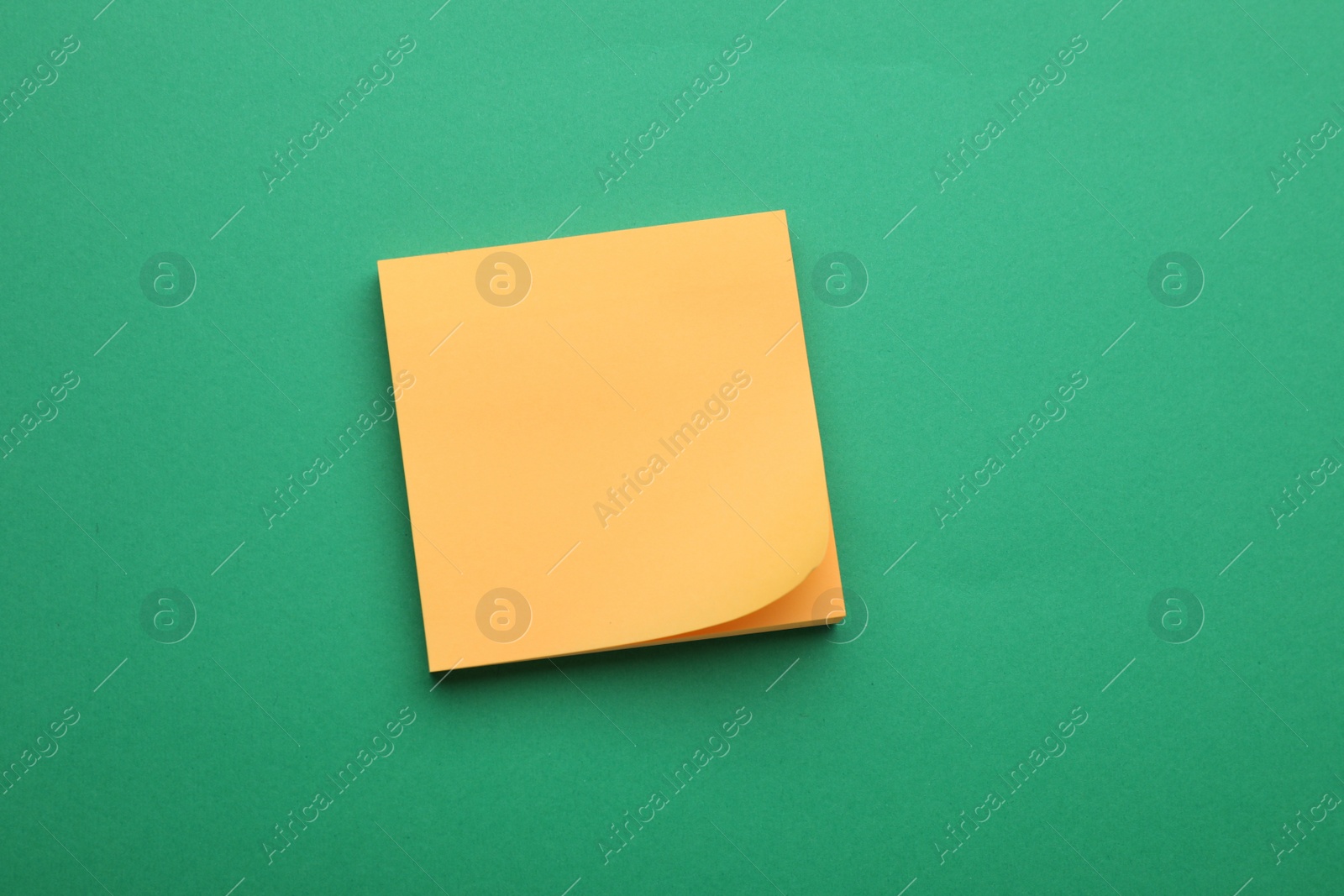Photo of Empty notes on green background, top view. Space for text