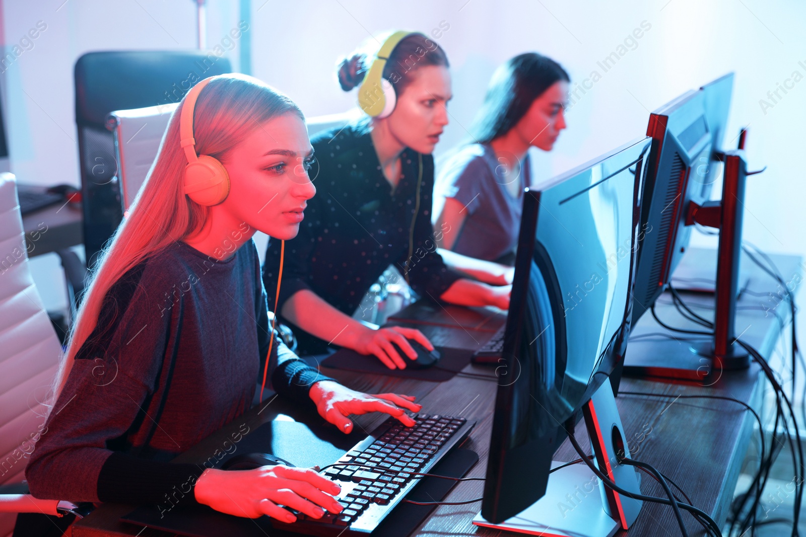 Photo of Young people playing video games on computers indoors. Esports tournament