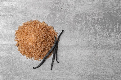 Photo of Aromatic vanilla sugar and sticks on grey background