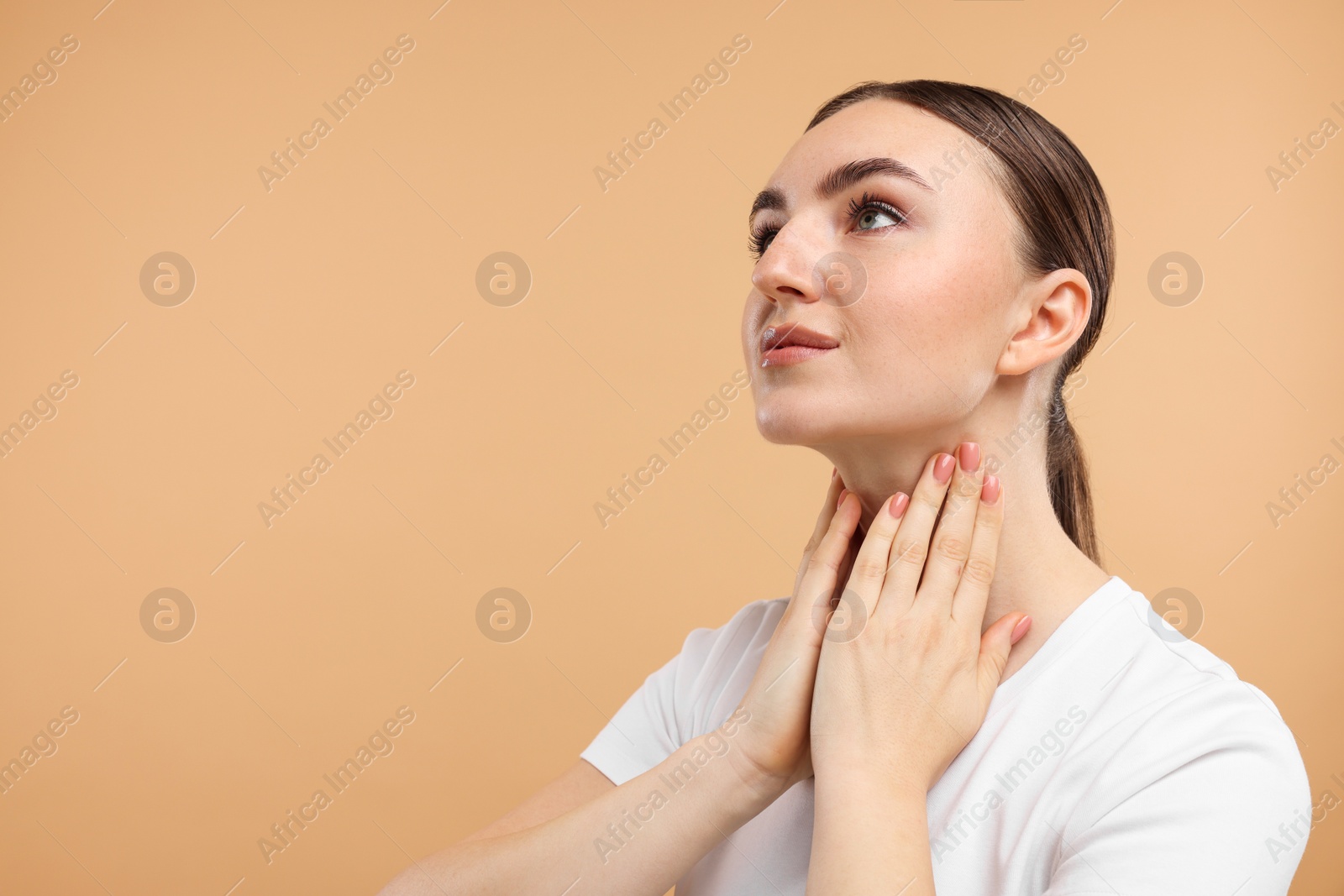 Photo of Beautiful woman touching her neck on beige background. Space for text