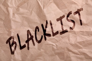 Black word Blacklist on crumpled beige paper